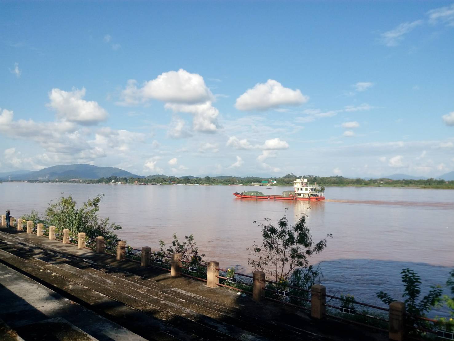 ภาพการขนส่งข้ามแดนบริเวณแม่น้ำโขง รถบรรทุก และเรือขนส่ง